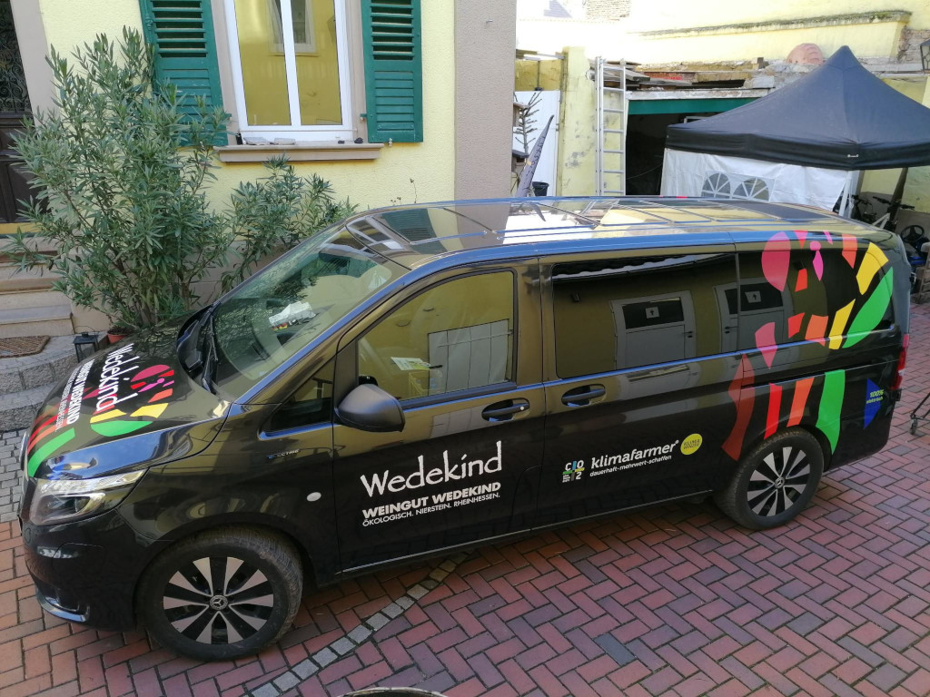 Ein schwarzer E-Lieferwagen mit der Aufschrift Weingut Wedekind Ökologisch Nierstein Rheinhessen 